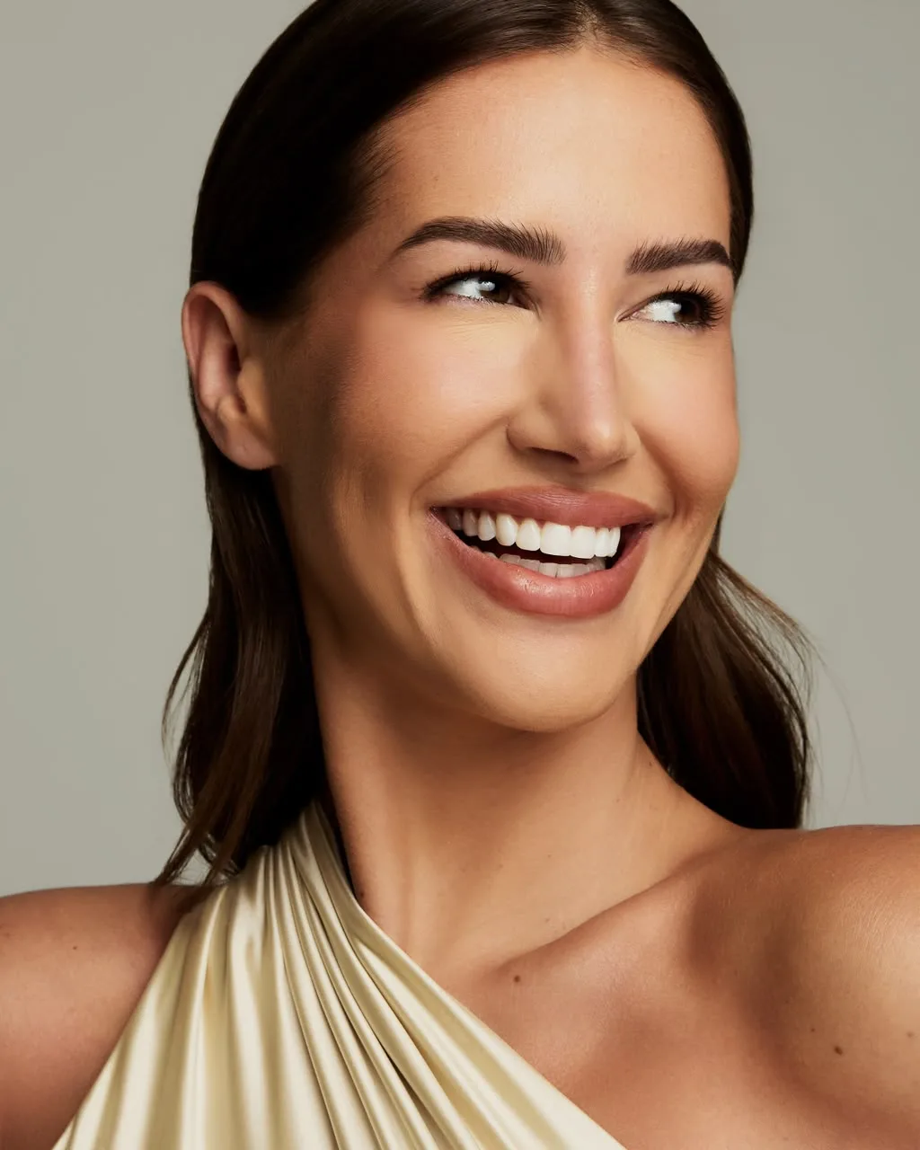 Retrato de beleza de Giovanna sorrindo, em cetim dourado