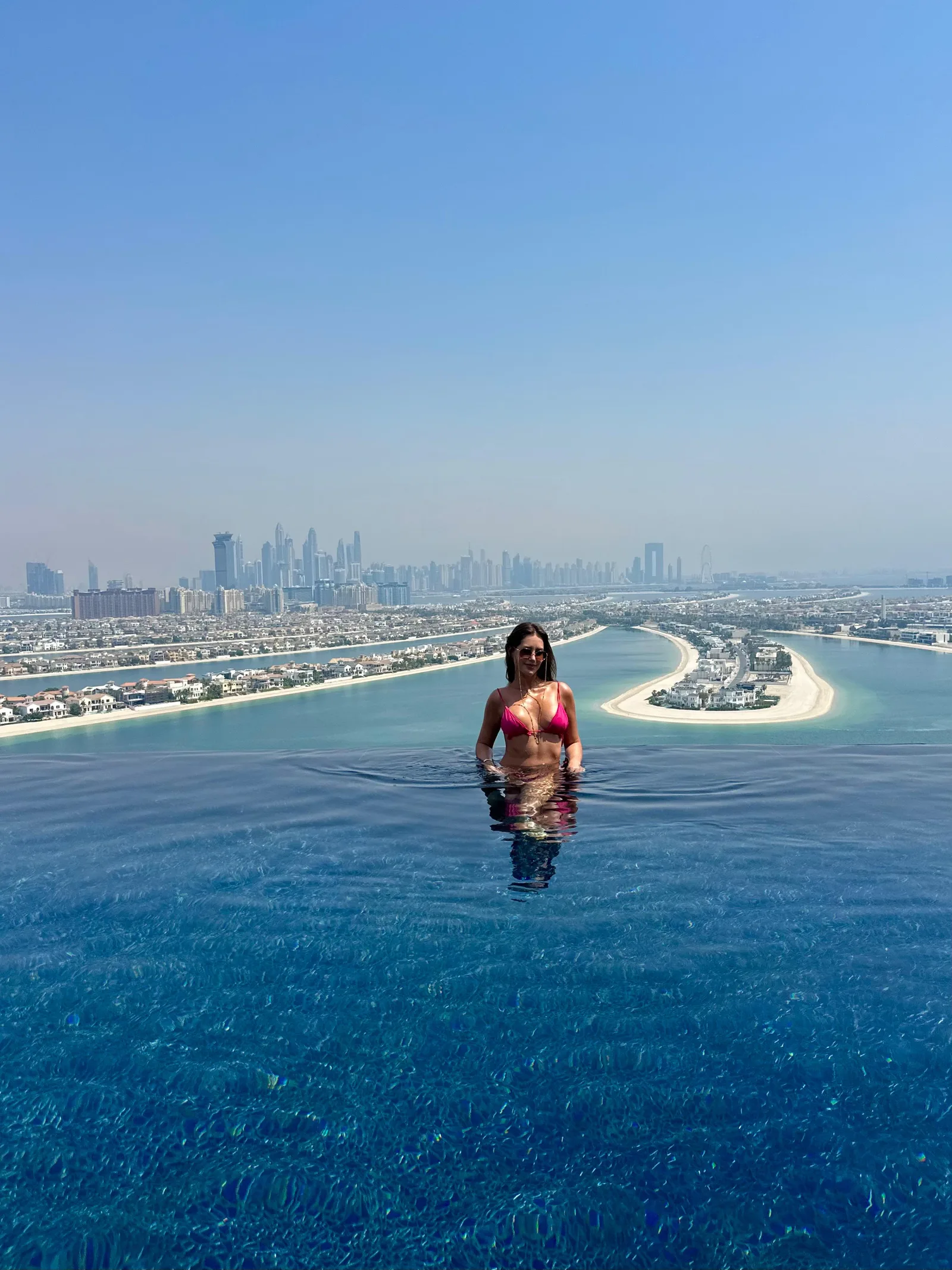 Giovanna na piscina Cloud 22 do Atlantis The Royal, em Dubai, com a Palm Jumeirah ao fundo